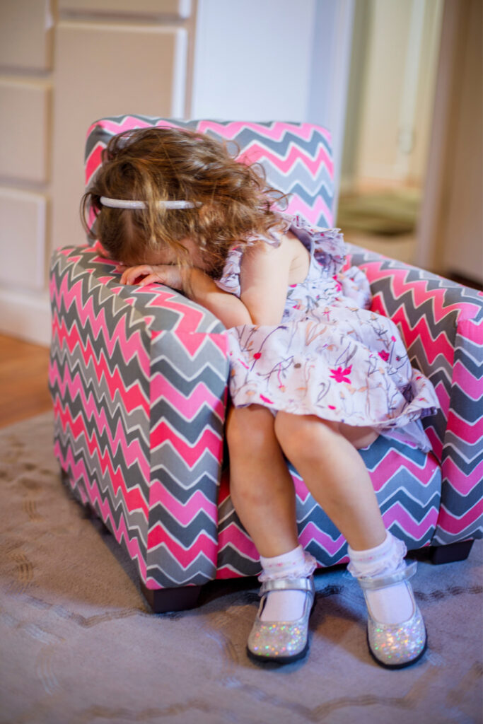 toddler girl crying on colorful chair