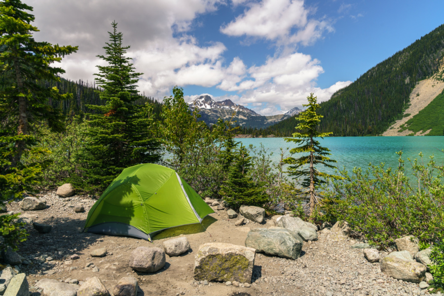 green tent camping at a lake