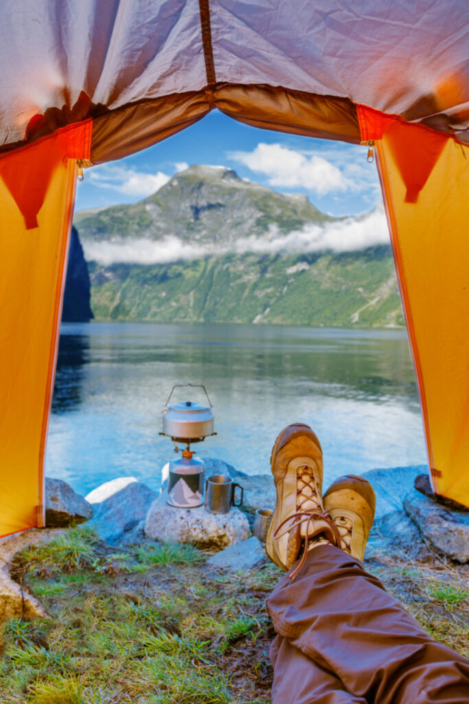 person camping inside tent by the lake